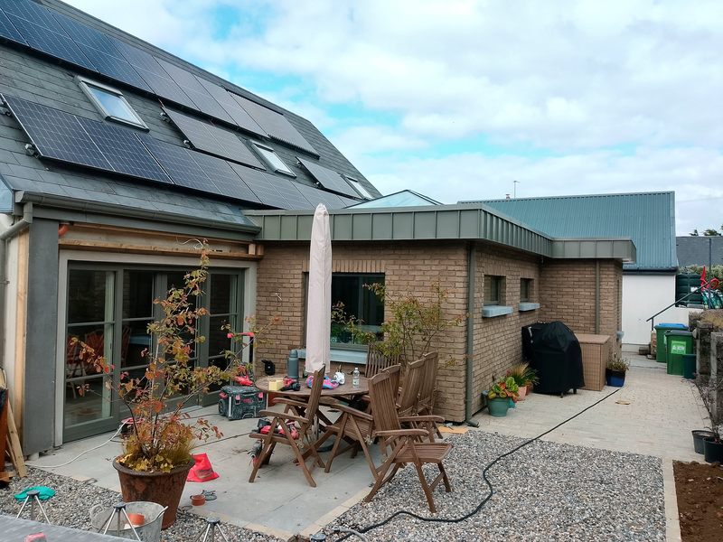Single-storey brick extension with metal fascia and large glazed doors opening onto a rear patio