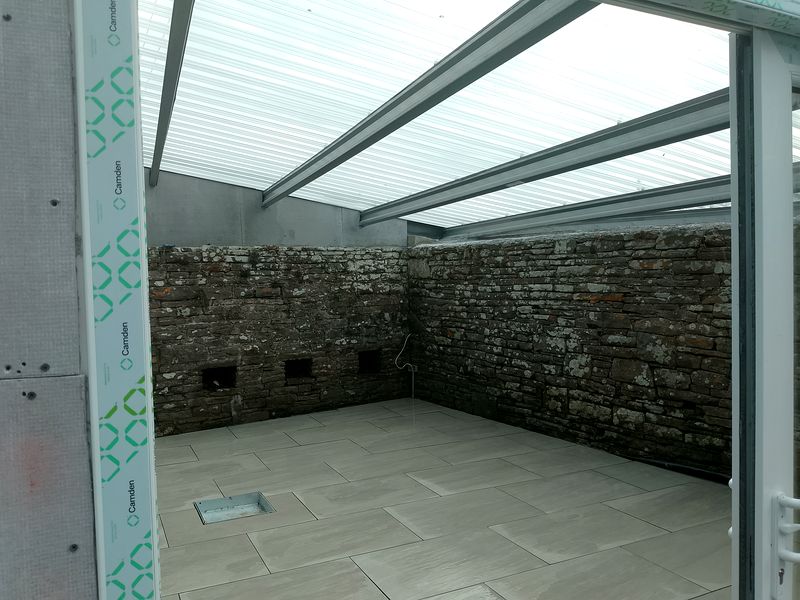 Conservatory with stone wall, paved floor and translucent polycarbonate roof, Liscannor