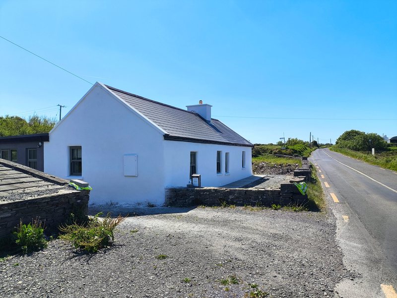 Traditional single-storey cottage with a slate roof and fresh white render in North Clare