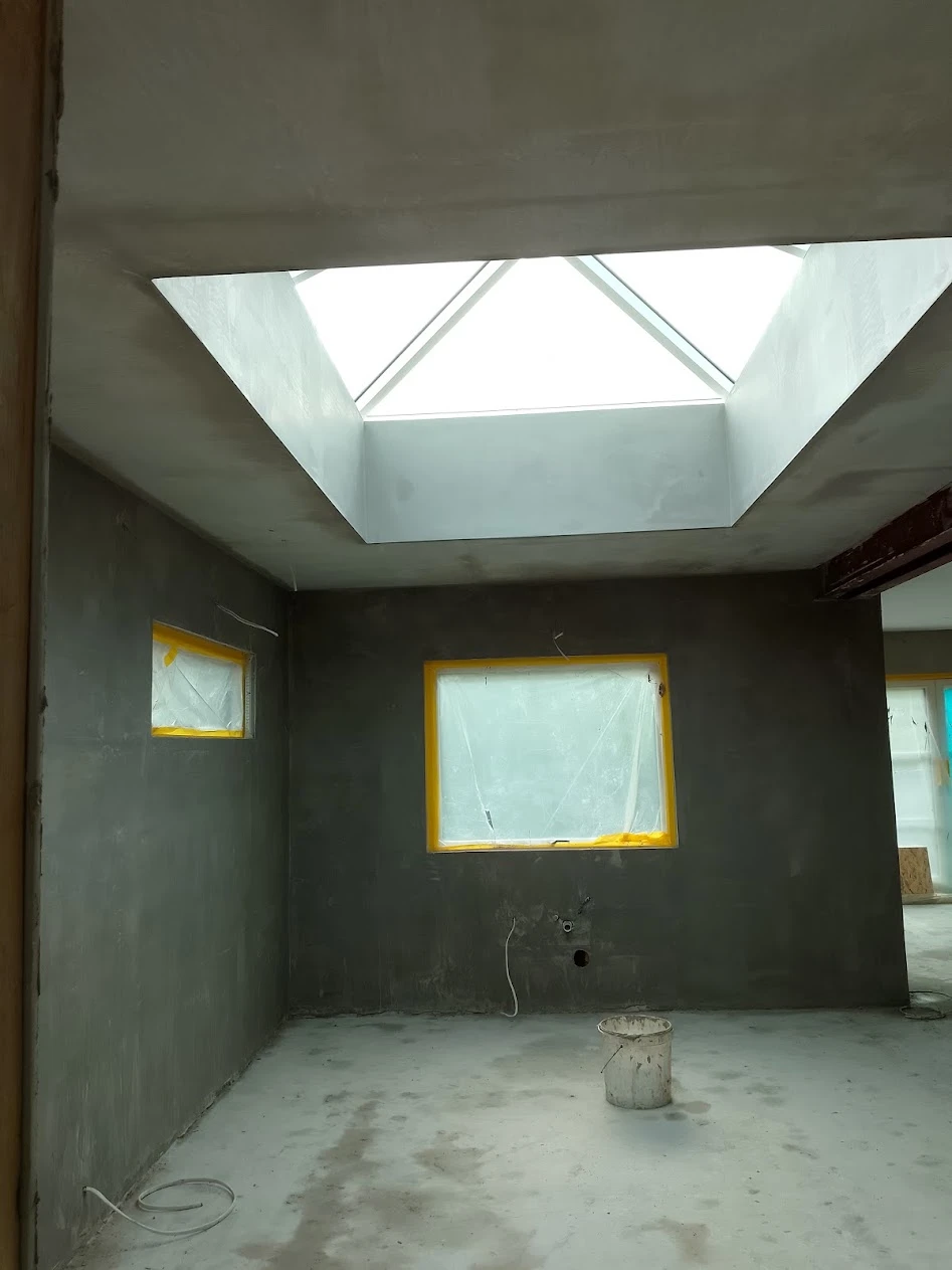New extension interior, freshly plastered, with a large roof lantern flooding the room with light
