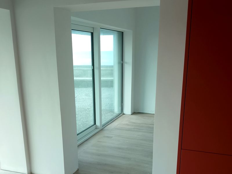 Finished extension interior with wood flooring and large sliding glass doors