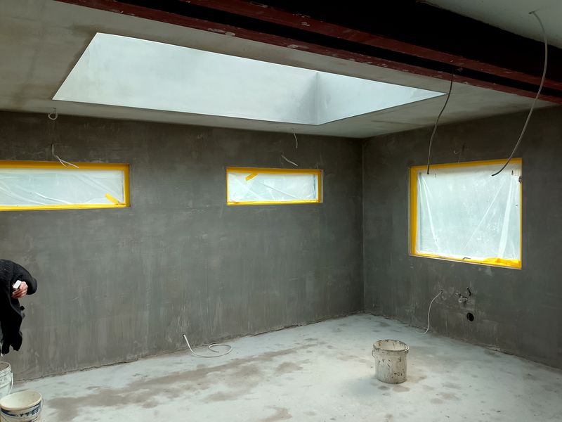 Freshly plastered extension interior with a large rectangular rooflight in the ceiling